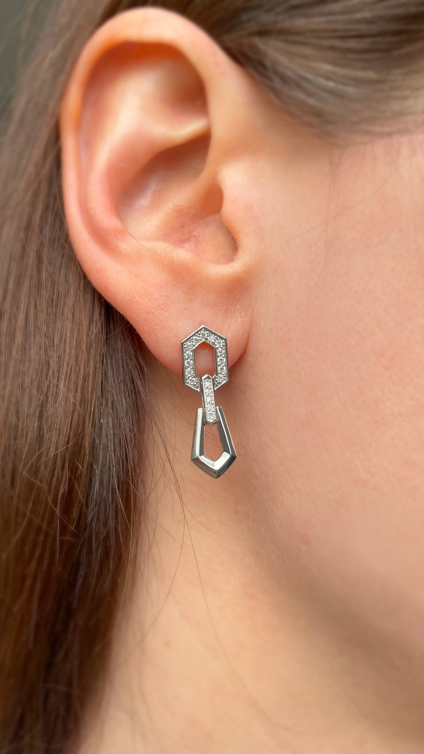 Złote kolczyki z cyrkoniami w nowoczesnym geometrycznym kształcie. Eleganckie złote kolczyki z błyszczącymi cyrkoniami. Damskie kolczyki złote z cyrkoniami, design geometryczny. Złote kolczyki sztyfty z ozdobnymi cyrkoniami. Stylowe kolczyki ze złotym wykończeniem i detalami z cyrkonii.