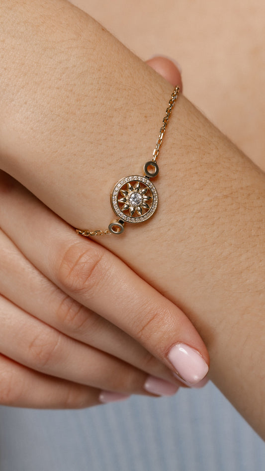 Złota bransoletka z zawieszką w kształcie słonecznika i centralną cyrkonią. Delikatna bransoletka złota z ozdobnym motywem słonecznika. Elegancka damska bransoletka.