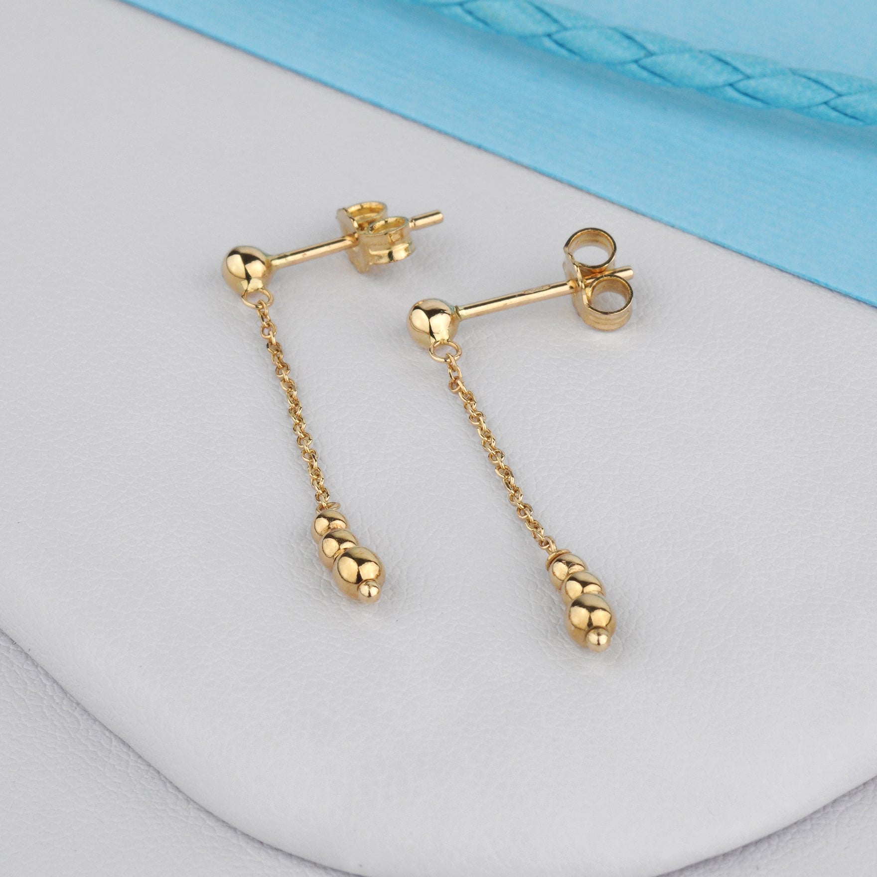 Delikatne kolczyki złote na łańcuszku z kulkami