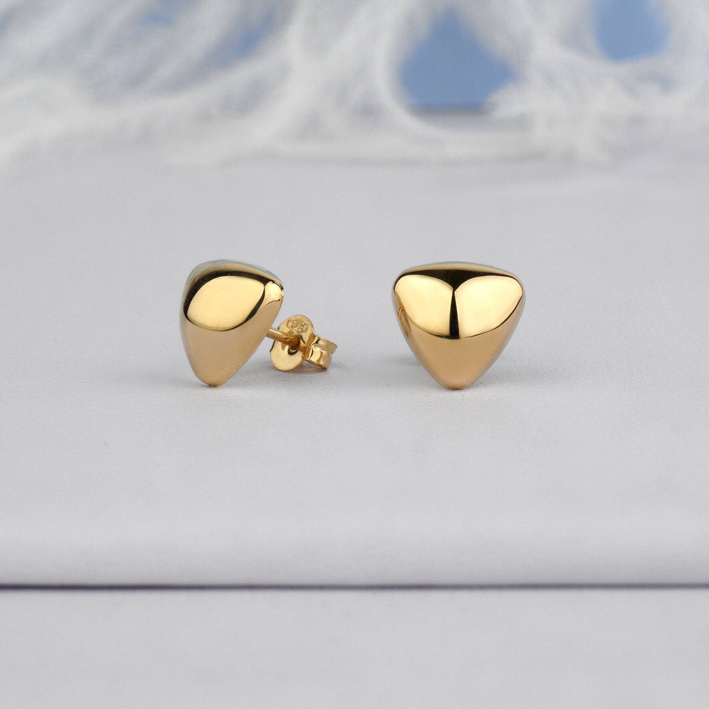 Eleganckie złote kolczyki trójkątne z połyskiem – nowoczesna minimalistyczna biżuteria.