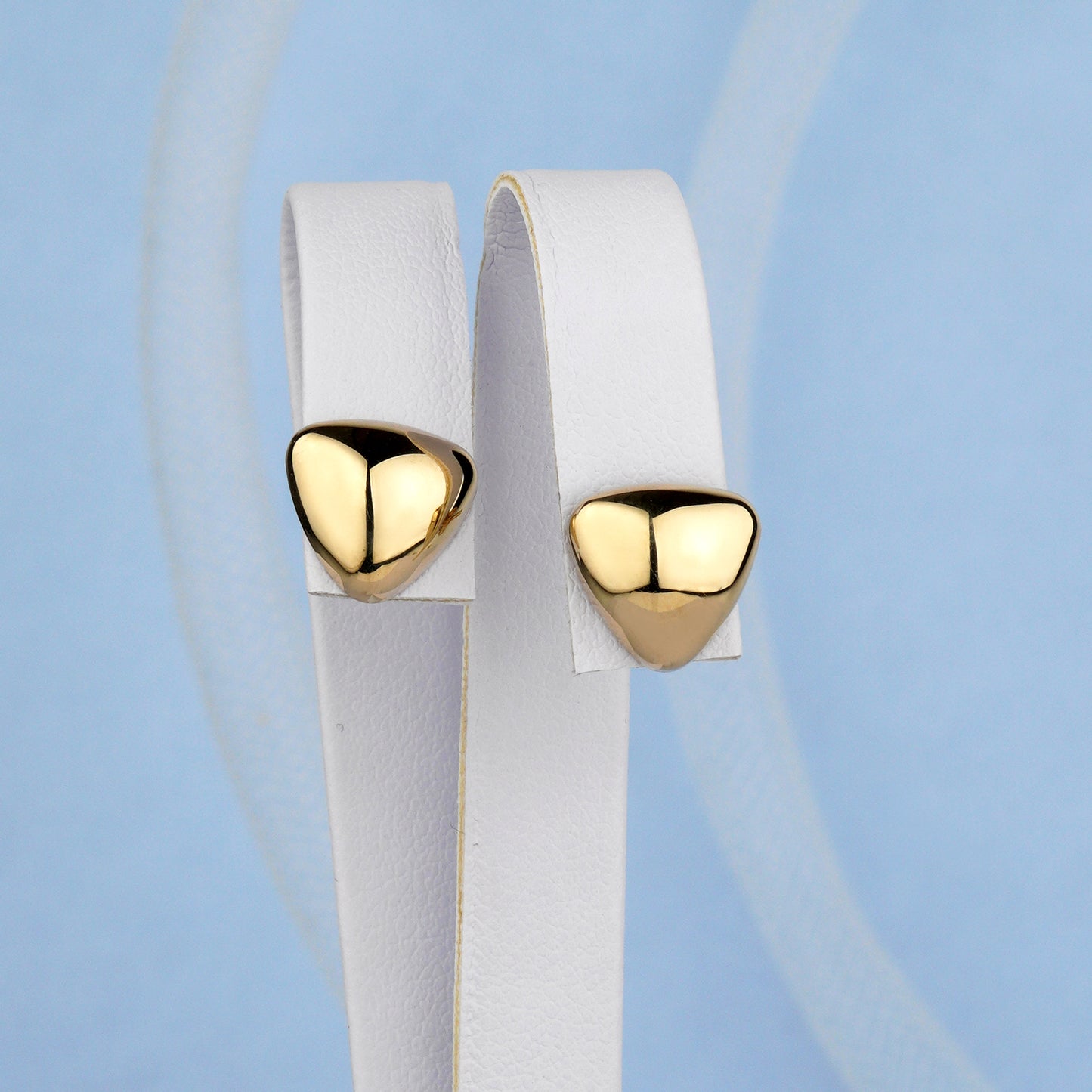 Złote kolczyki w kształcie trójkąta z gładkim, wypukłym wykończeniem – elegancka minimalistyczna biżuteria.