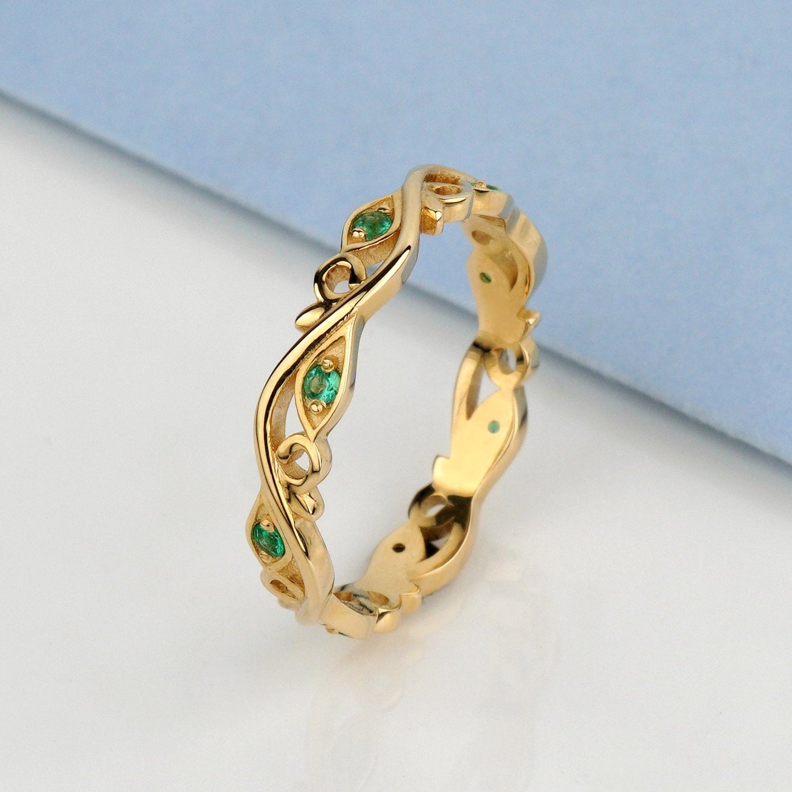 Złota obrączka ze szmaragdami i motywem kwiatowym 585